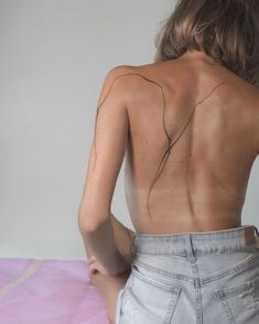 the back of a woman's body with lines drawn on her left shoulder and right arm