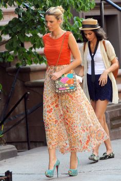 two women walking down the street with one carrying a purse and another holding a handbag