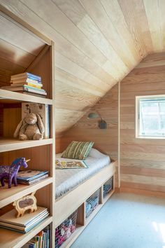 there is a bed in the room with bookshelves and stuffed animals on it