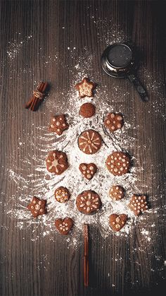 a christmas tree made out of cookies on top of a wooden table with cinnamon sticks