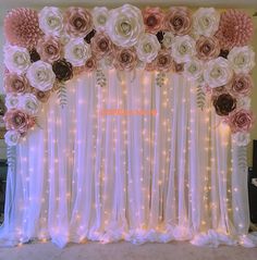 the backdrop is decorated with flowers, lights and sheer curtains for a wedding ceremony or special event