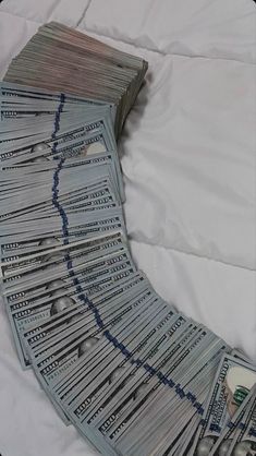 a pile of money sitting on top of a bed