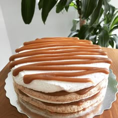 a stack of cookies with caramel drizzles on top sitting on a table