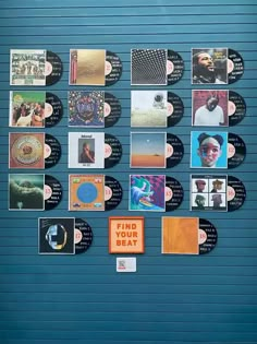 a blue wall covered in lots of different types of vinyl records on it's side