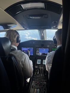 two pilots sitting in the cockpit of an airplane