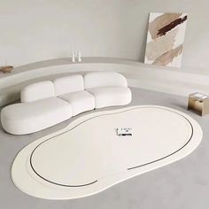 a large white couch sitting on top of a floor next to a table and chair