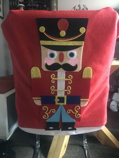 an image of a nutcracker made out of red material on a chair in a room