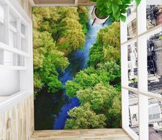 an open window with a view of a river running through the trees in front of it