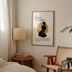 a poster hangs on the wall above a bed in a room with two chairs and a lamp