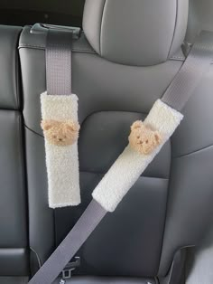 two teddy bears are attached to the seat belt