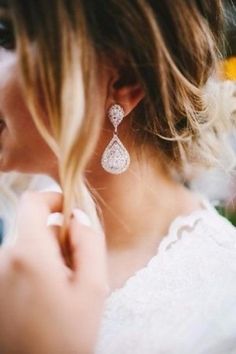 a woman in white dress with earrings on her ear and the words wedding date written below it