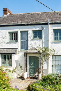 a white house with green doors and windows