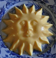 a blue and white plate with a sun cookie on it's side, in the shape of a face