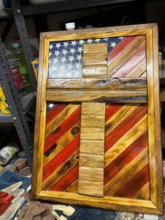 a wooden cross with an american flag painted on it in front of some other items