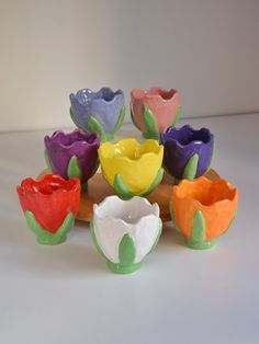 there are many different colored vases sitting on a wooden tray with one flower in the middle