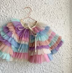 Mama tulle ruffle dress up cape Made from good quality soft tulle, backed with neutral cotton and finished with Neutral cotton herringbone tape. Tie fasteningPastel Rainbow mash up colour way Mama sizeOne size Keep away from fire Tulle Ruffle Dress, Dress Up Clothes, Costume Capes, Kids Dress Up, Kids Necklace, Soft Tulle, Girl Decor, Pink Sequin, Pastel Rainbow