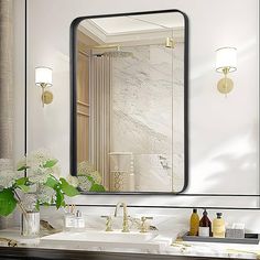 a bathroom vanity with a large mirror above it and flowers in the vase on the counter