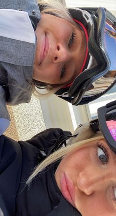 two women wearing helmets and goggles are posing for the camera with their faces close together