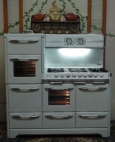 a white stove top oven sitting inside of a kitchen next to a wall with words above it