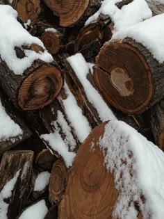 snow covered logs are stacked on top of each other