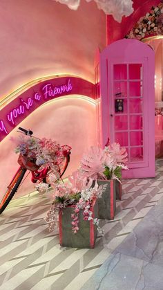 there is a pink room with flowers and a bike