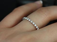 a woman's hand with a diamond ring on her left hand, showing the side view