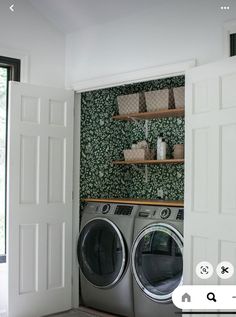 a washer and dryer in a room with green wallpaper on the walls