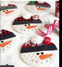 four snowman ornaments are sitting on a table