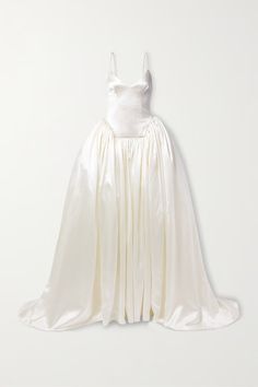 a white wedding dress on display against a wall