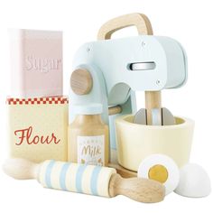 a toy kitchen set with wooden utensils and flour