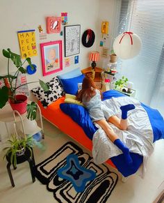 a woman laying in her bed with pillows and blankets on top of the bedspread