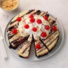 a cheesecake topped with whipped cream and cherries