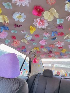 the interior of a car decorated with colorful paper flowers and butterfly decorations on the ceiling