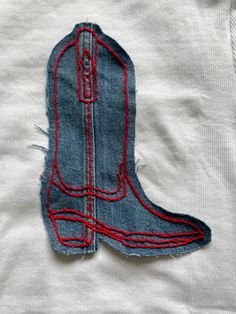 an old pair of jeans has been stitched into the shape of a cowboy boot