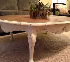 a coffee table with a sign that says dreams on it sitting in front of a couch