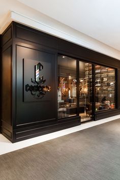 the inside of a wine store with glass doors and black lettering on the front wall