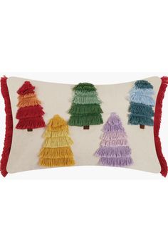 a decorative pillow with fringe trims and trees on it's sides in different colors