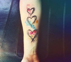 two hearts tattoo on the left inner arm and foot, with watercolor splashes