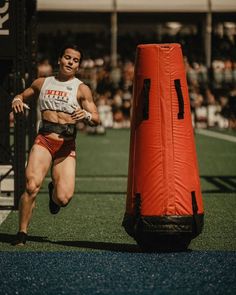 a woman running next to a red punching bag