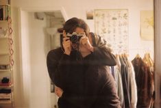 a woman taking a selfie in front of a mirror while holding a camera up to her face