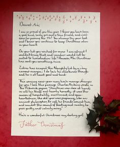 a christmas letter written in red and black ink with holly sprigs on it