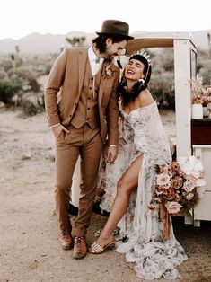 a man and woman standing next to each other in front of a desert wedding car