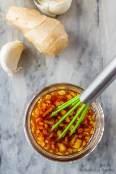 a glass jar filled with food next to garlic