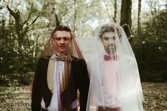 a man and woman dressed in wedding attire standing next to each other with veils over their heads