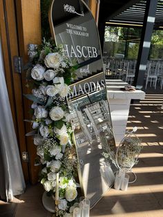 a floral display in front of a building with white flowers and greenery on it