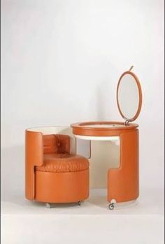 an orange chair and ottoman in front of a white wall with a mirror on it