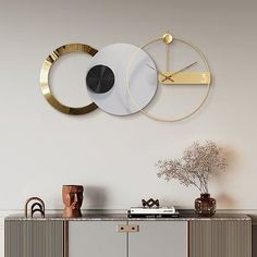 a white and gold sideboard with a clock on it's face next to a vase