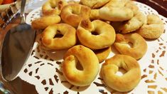 several donuts on a doily with a spoon in the middle and carrots in the background