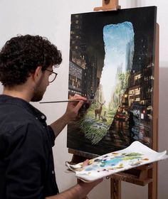 a man is painting on an easel in front of a cityscape