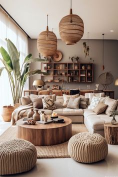 a living room filled with lots of furniture and hanging lights over the top of it